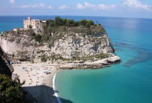 a group of people laying on a beach in the ocean at Residenza Eolo in Tropea