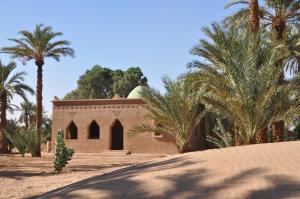 un piccolo edificio con palme di fronte di Hotel Kasbah Azalay a M'Hamid