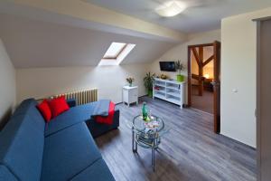 a living room with a blue couch and a glass table at Hotel Panorama in Pilsen