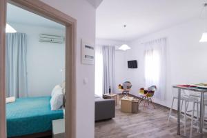 Un dormitorio con una cama y una habitación con una mesa. en Breeze Vacation Apartments, en Plakias