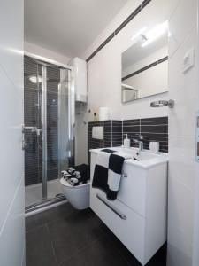 a white bathroom with a toilet and a sink at SunnyHomePunta in Sukošan