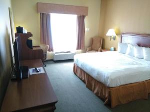 a hotel room with a large bed and a window at Baymont by Wyndham Clinton in Clinton