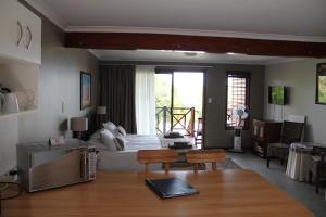a hotel room with a bed and a table and chairs at Horizon Cottages in Noordhoek