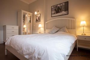 a bedroom with a large white bed and two lamps at Presidency House Self Check-in Apartments in Sofia