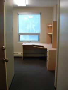 um quarto vazio com uma secretária e uma janela em University of Alberta - Accommodation em Edmonton