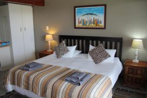 a bedroom with a bed with towels on it at Horizon Cottages in Noordhoek +72 photos