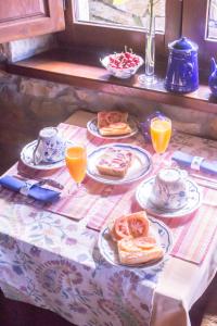Posada Rural Valoria في Valoria: طاولة مليئة بأطباق الطعام وعصير البرتقال