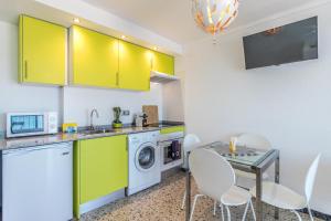 エンプリアブラバにあるHolidays P14 Sea Viewのキッチン(黄色のキャビネット、テーブル、椅子付)