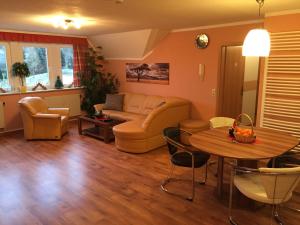 ein Wohnzimmer mit einem Sofa und einem Tisch in der Unterkunft Pöhlbergblick Annaberg in Annaberg-Buchholz