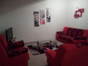uma sala de estar com dois sofás vermelhos e uma mesa em Apartments Villa Lavanda em Zadar