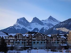 a resort with snow covered mountains in the background at Sunset Resorts Canmore and Spa in Canmore