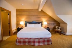 
a hotel room with a bed and a dresser at Trapp Family Lodge in Stowe
