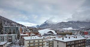 una ciudad con una montaña cubierta de nieve en el fondo en Hard Rock Hotel Davos, en Davos