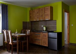 a kitchen with a table and a green wall at Apartamenty u Klisia in Ząb