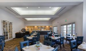 ein Esszimmer mit Tischen und blauen Stühlen in der Unterkunft Best Western Posada Royale Hotel & Suites in Simi Valley