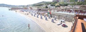 a beach with umbrellas and people in the water at Casa Lucrino in Pozzuoli