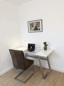 a white desk with a chair and a laptop on it at Hugo18 Boardinghouse in Kandel