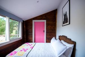 a bedroom with a pink door and a bed at Chum Creek Hut in Chum Creek