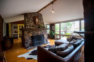 a living room with a couch and a stone fireplace at Chum Creek Hut in Chum Creek