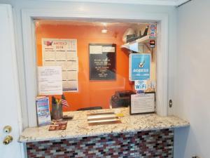 a restaurant counter with an orange wall at Value Inn Hollywood in Los Angeles