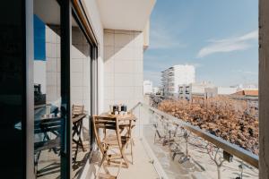 a balcony with a table and chairs and a view of a city at Casa da Avenida in Olhão