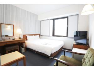 um quarto de hotel com uma cama e uma televisão em Smile Hotel Nihombashi Mitsukoshimae em Tóquio