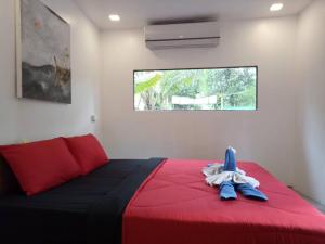 a bedroom with a bed with red and blue sheets at Ozone Beach Huts in Ko Lanta