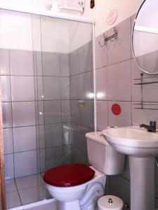 a bathroom with a red toilet and a sink at Pousada Atlantis in Jericoacoara