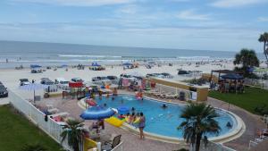 a pool at a beach with people playing in it at Driftwood Beach Motel in Ormond Beach