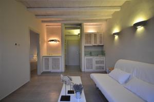 a living room with a white couch and a table at Portes Houses in Koufonisia