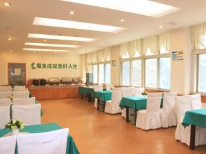 una sala banchetti con tavoli e sedie verdi e bianchi di GreenTree Inn Anhui Huainan Liulizhan Express Hotel a Huainan