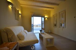 a living room with a couch and a table and a window at Portes Houses in Koufonisia