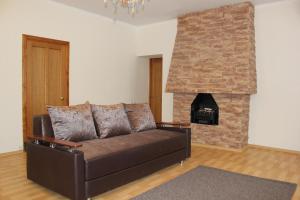 a living room with a couch and a brick fireplace at Elektron Hotel in Novosibirsk