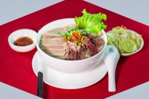 a bowl of meat and vegetables on a red tray at Pyramid Hotel & Spa in Sisophon 
