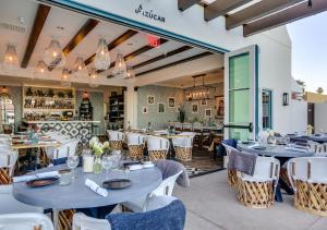 a restaurant with tables and chairs and a bar at La Serena Villas, A Kirkwood Collection Hotel in Palm Springs