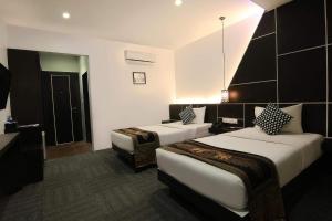 a hotel room with two beds in a room at Pyramid Hotel & Spa in Sisophon 