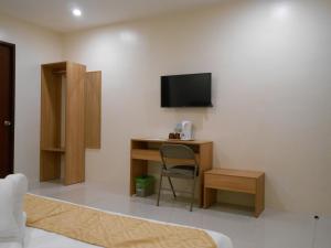 a room with a desk and a tv on a wall at Rublin Hotel Cebu in Cebu City