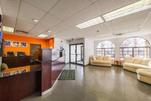 un vestíbulo de oficina con sofás y paredes de color naranja en Motel 6-Amarillo, TX, en Soncy