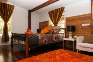 a bedroom with a large bed and a chair at Mudstone Spa Retreat in Pemberton