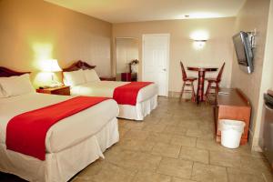 um quarto de hotel com duas camas e uma mesa em Lake Grassy Inn & Suites em Lake Placid