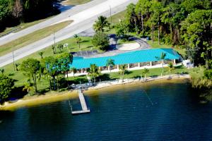une île dans l'eau avec un bâtiment bleu dans l'établissement Lake Grassy Inn & Suites, à Lake Placid