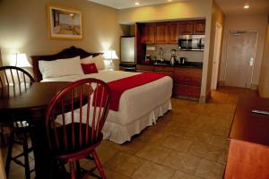 a bedroom with a bed and a desk and a kitchen at Lake Grassy Inn & Suites in Lake Placid