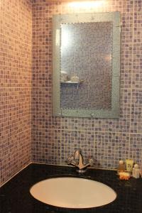 a bathroom with a sink and a mirror at Anse Norwa Self Catering in Mahe