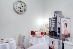 ローマにあるLunaria Suites Rome Vaticanoのテーブル付きのキッチン、壁掛け時計