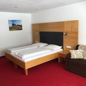 クレスターレ・アム・アールベルクにあるApart Sportivaのベッドルーム1室(大型ベッド1台、木製ヘッドボード付)
