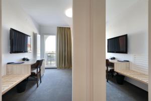 a room with two desks and a television on the wall at Hotel Mediteran in Zadar