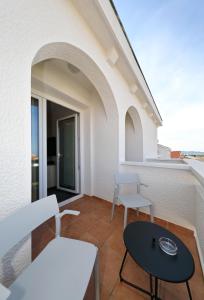 a balcony with a table and chairs on a building at Hotel Mediteran in Zadar