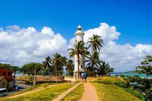a lighthouse on a hill with people walking past it at Hasara Hotel Galle in Galle