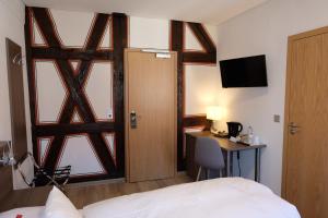 a room with a bed and a desk and a window at Gästehaus zur Sonne in Bad Wimpfen