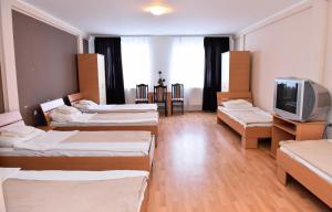 a room with four beds and a tv in it at Hostel Milkaza in Novi Sad